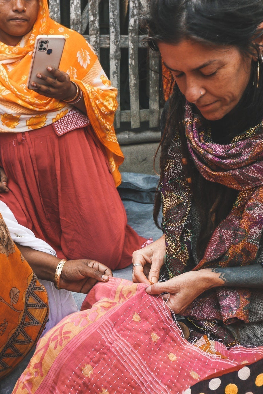 woman being taught how to kantha stitch