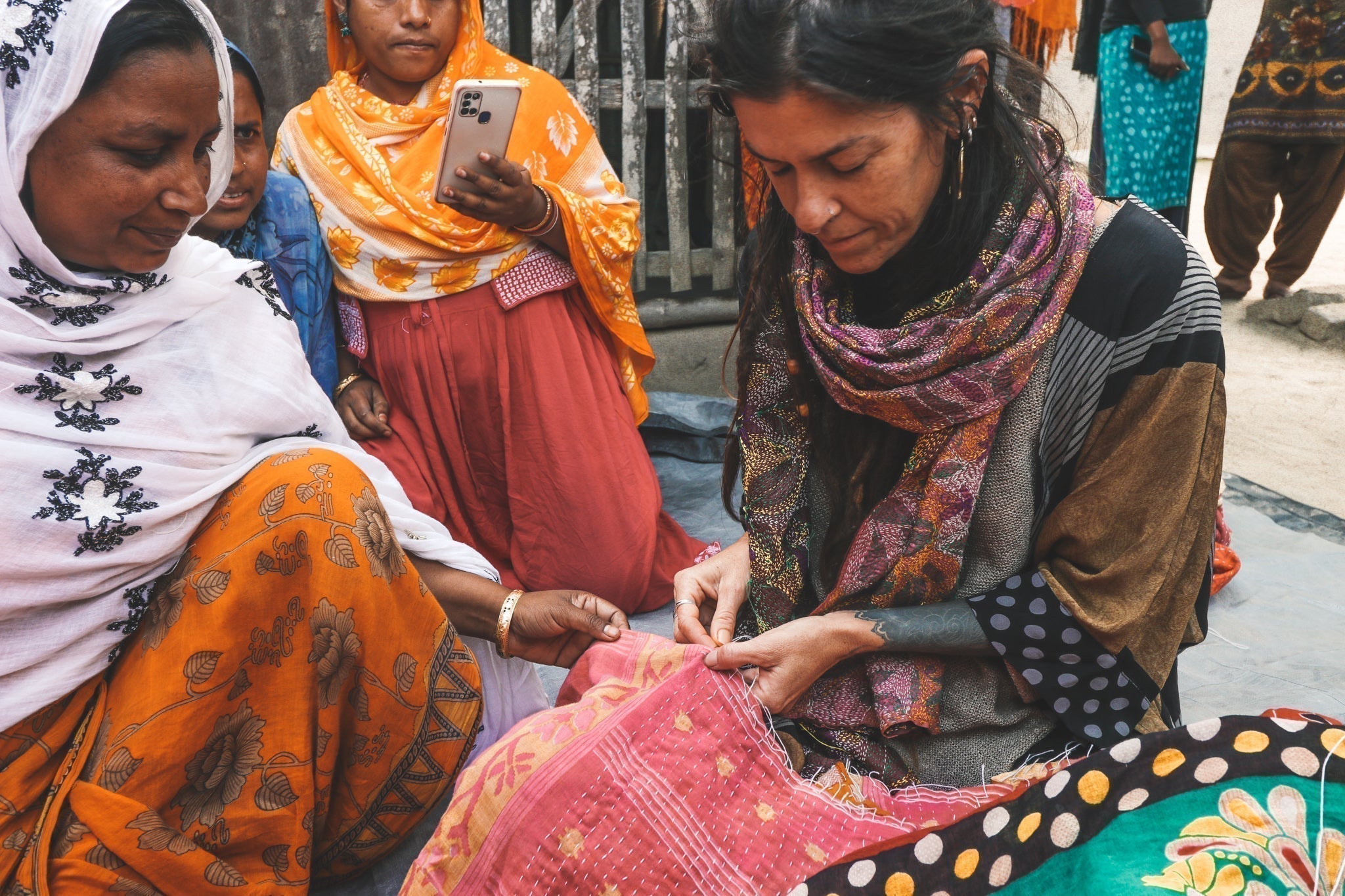 woman being taught how to kantha stitch