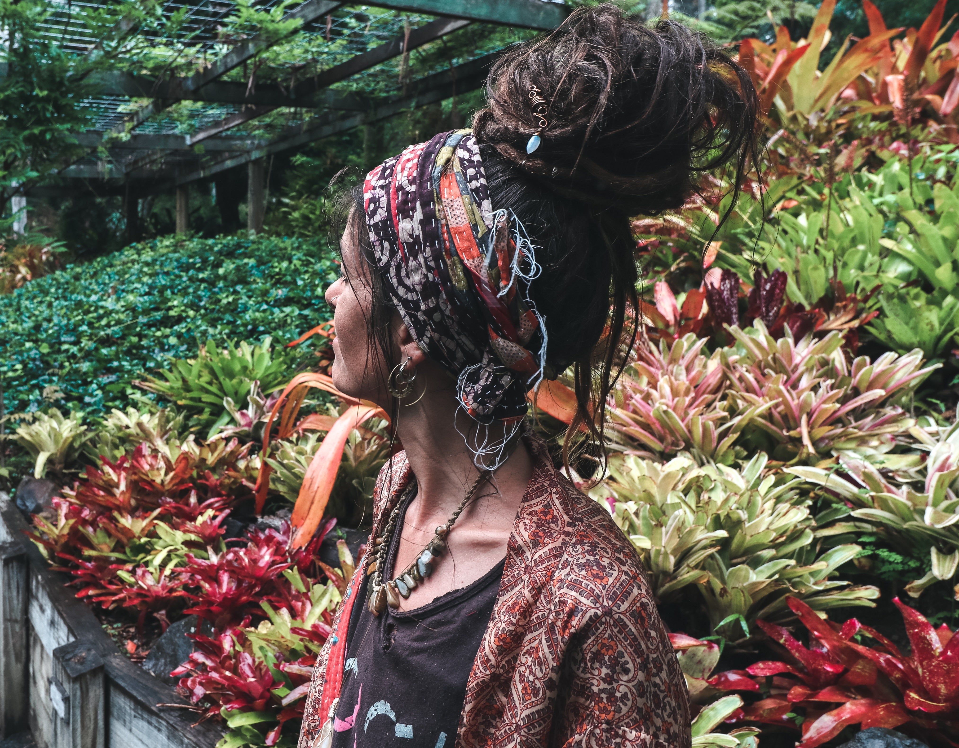 Profile view of woman with dreadlocks wearing colourful kantha headscarf