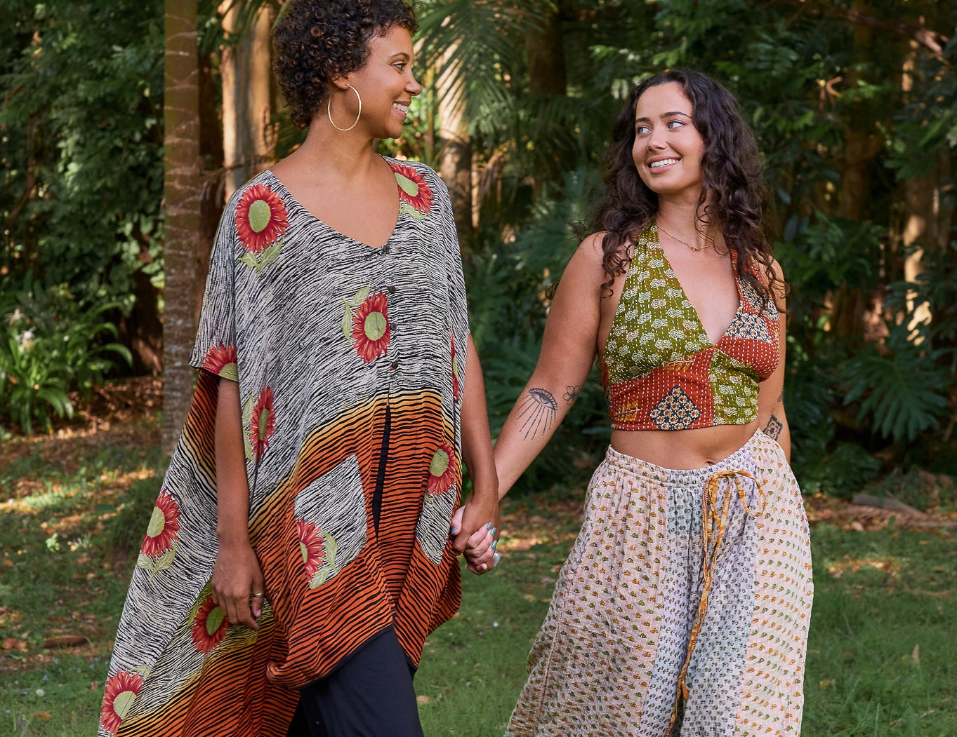 Two women walking hand in hand in a garden setting