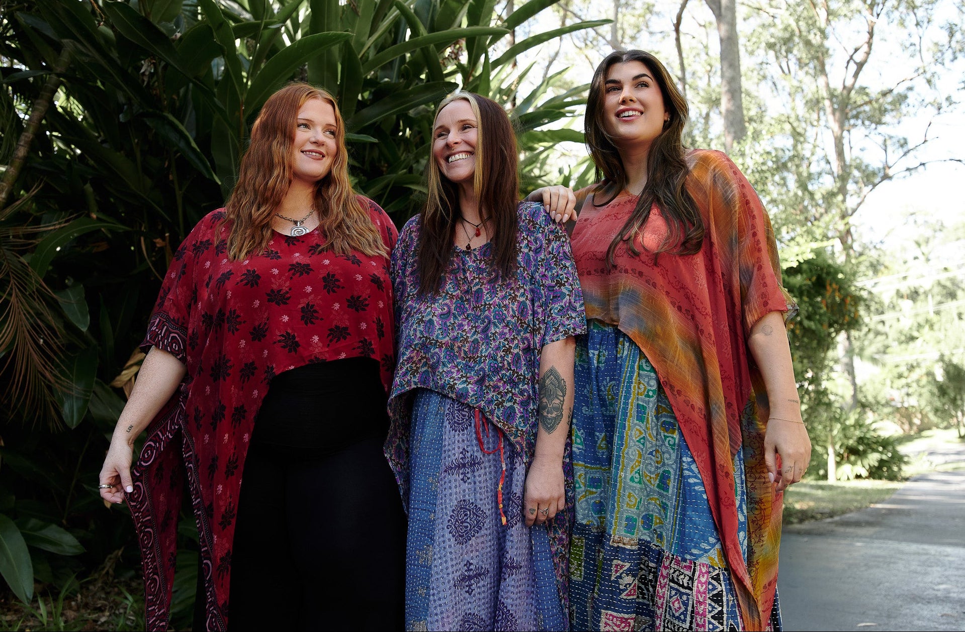 Three women standing outdoors with a natural background