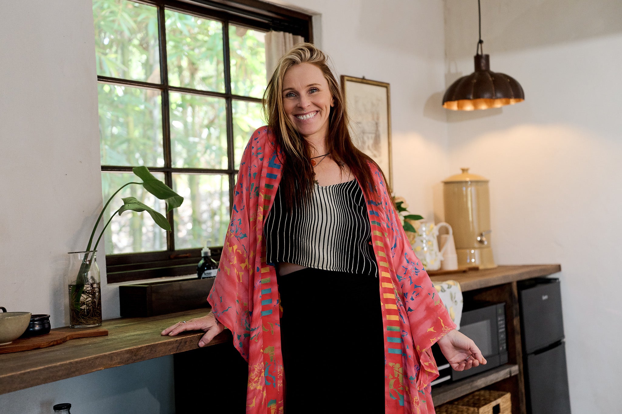 Woman standing in a kitchen wearing a colorful scarf