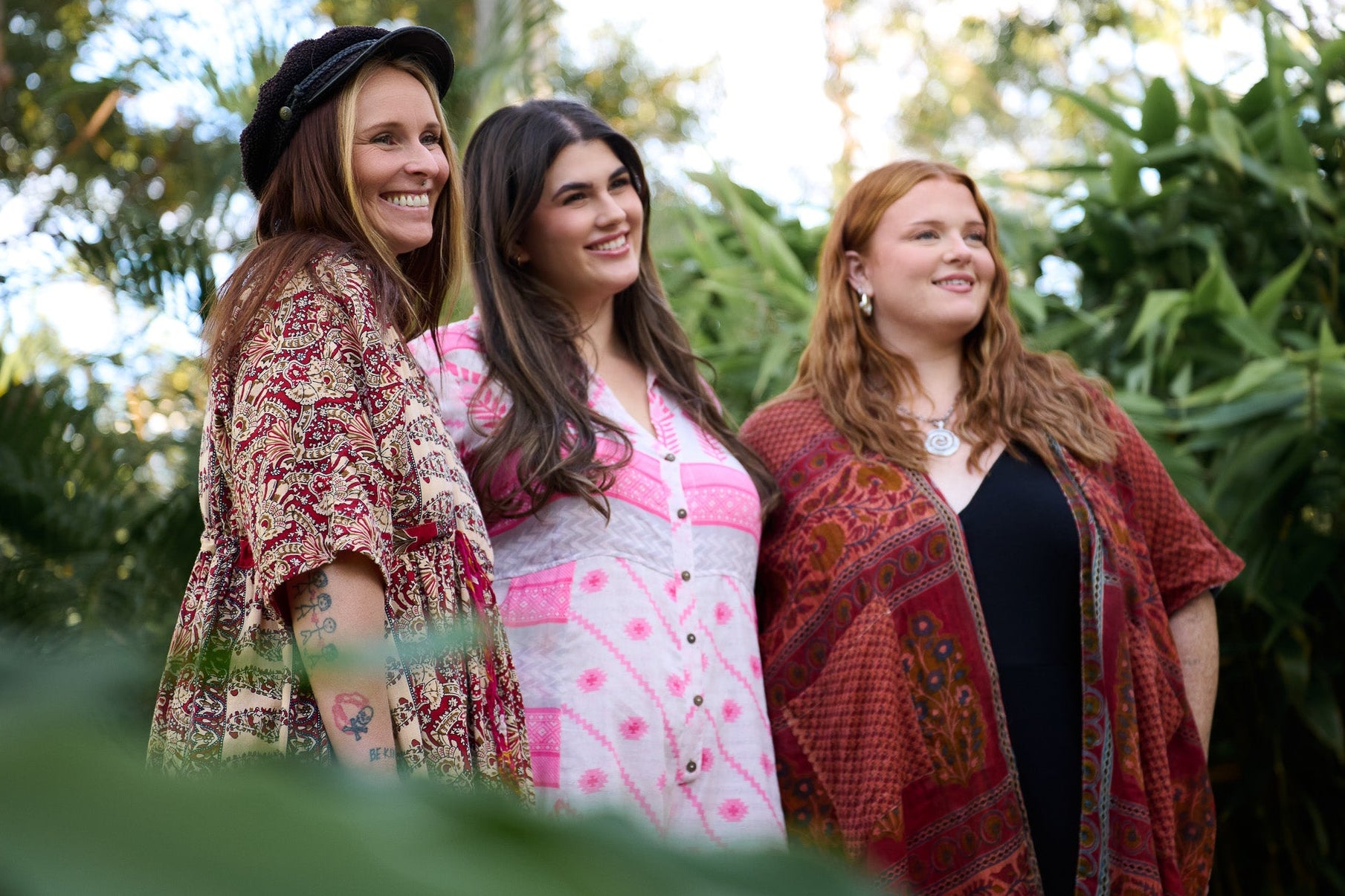 Three women standing outdoors with a natural background