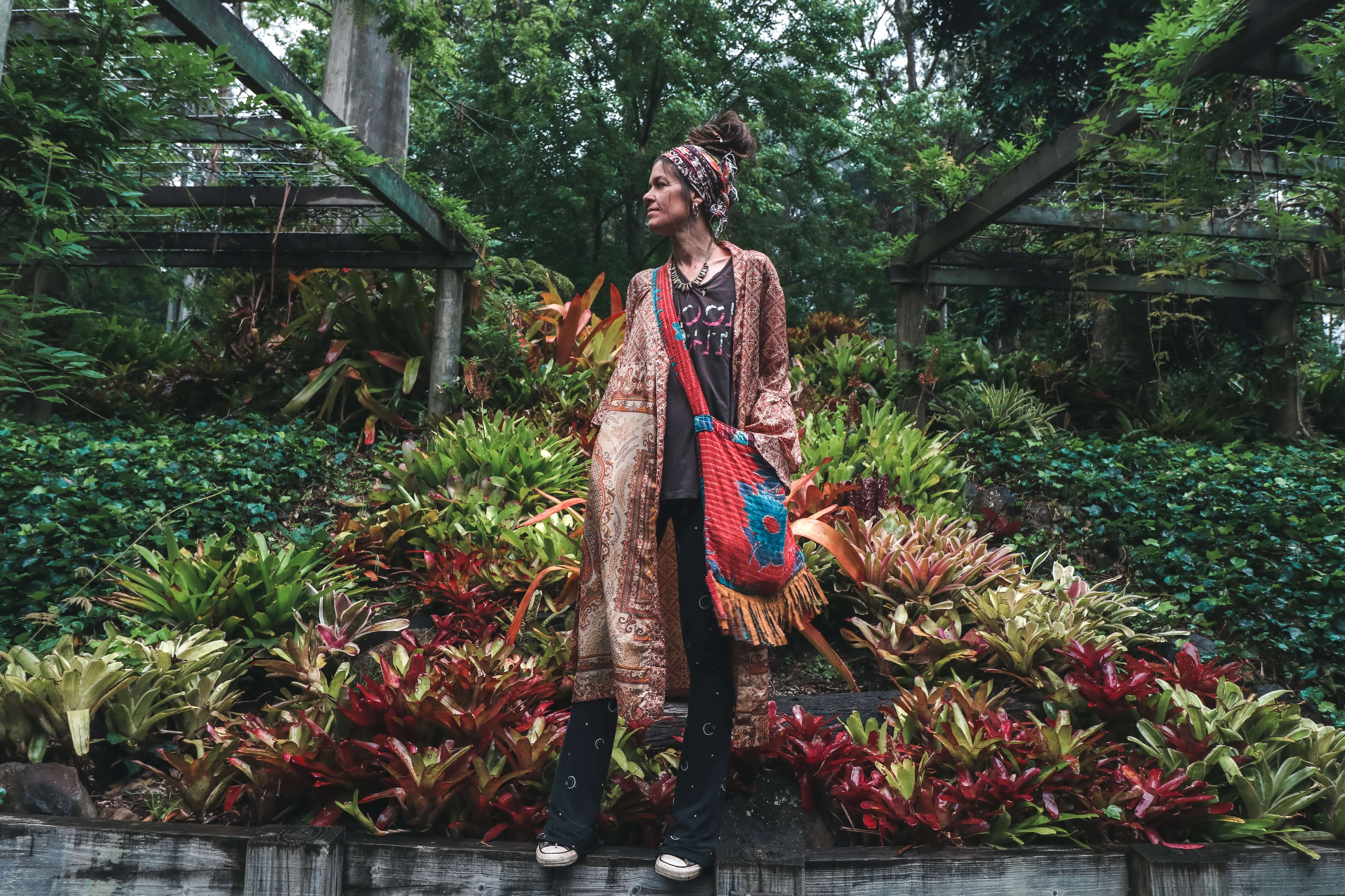 Woman standing in lush green park wearing colourful clothes
