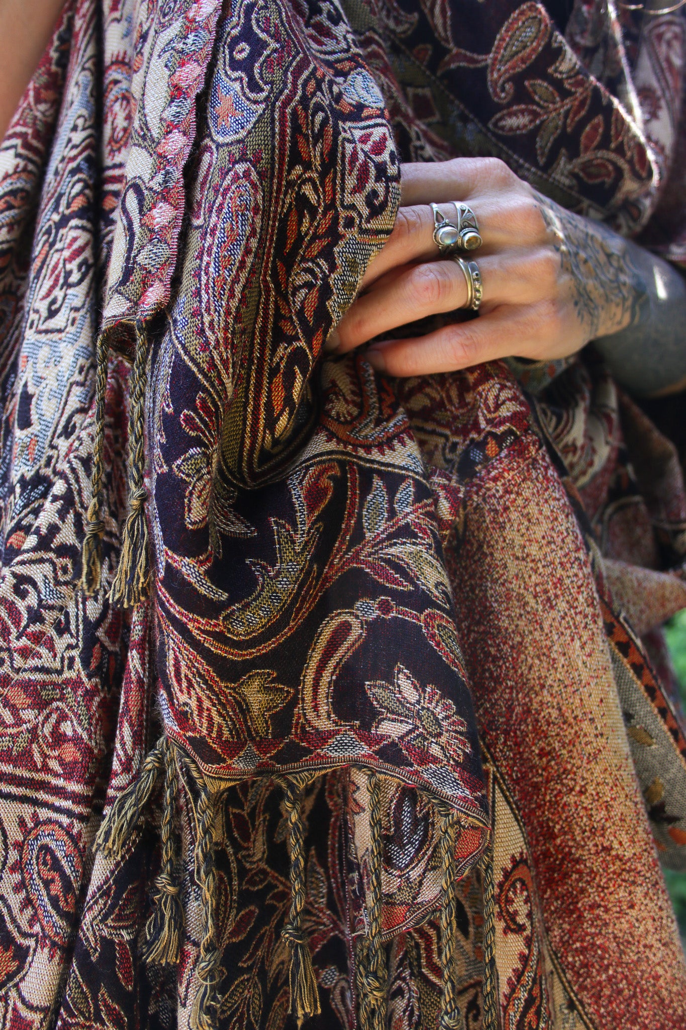 Close-up of a hand holding a patterned fabric with intricate designs.